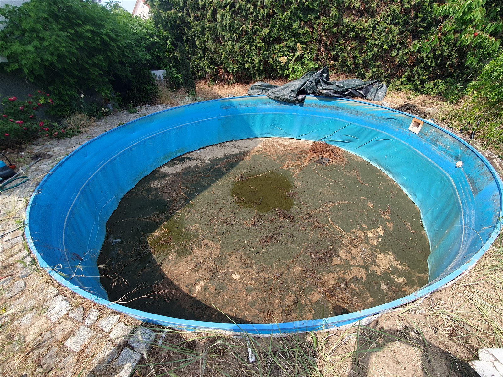 Entleertes altes Poolbecken mit blauer Innenauskleidung