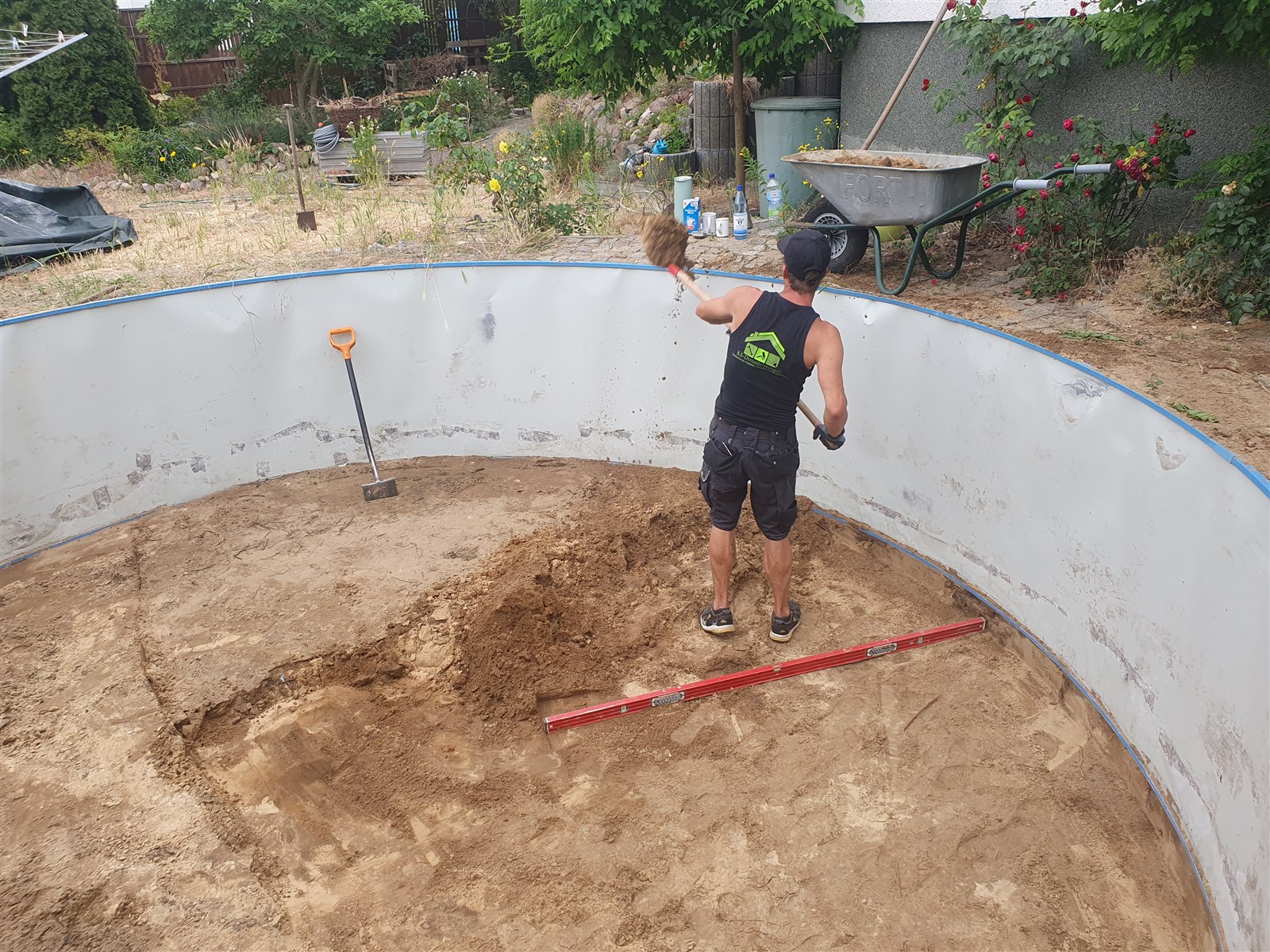 Bodenarbeiten im Poolbereich mit Schaufel und Schubkarre