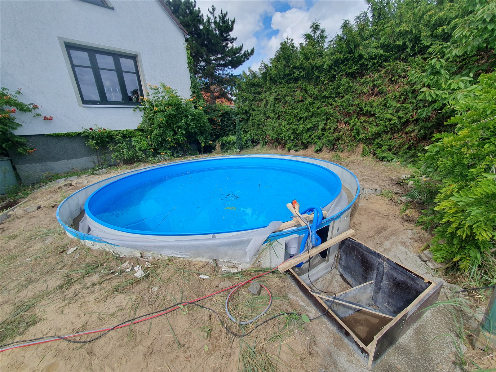 Neuer Stahlwandpool mit Wasser gefüllt und noch unbebauter Umgebung