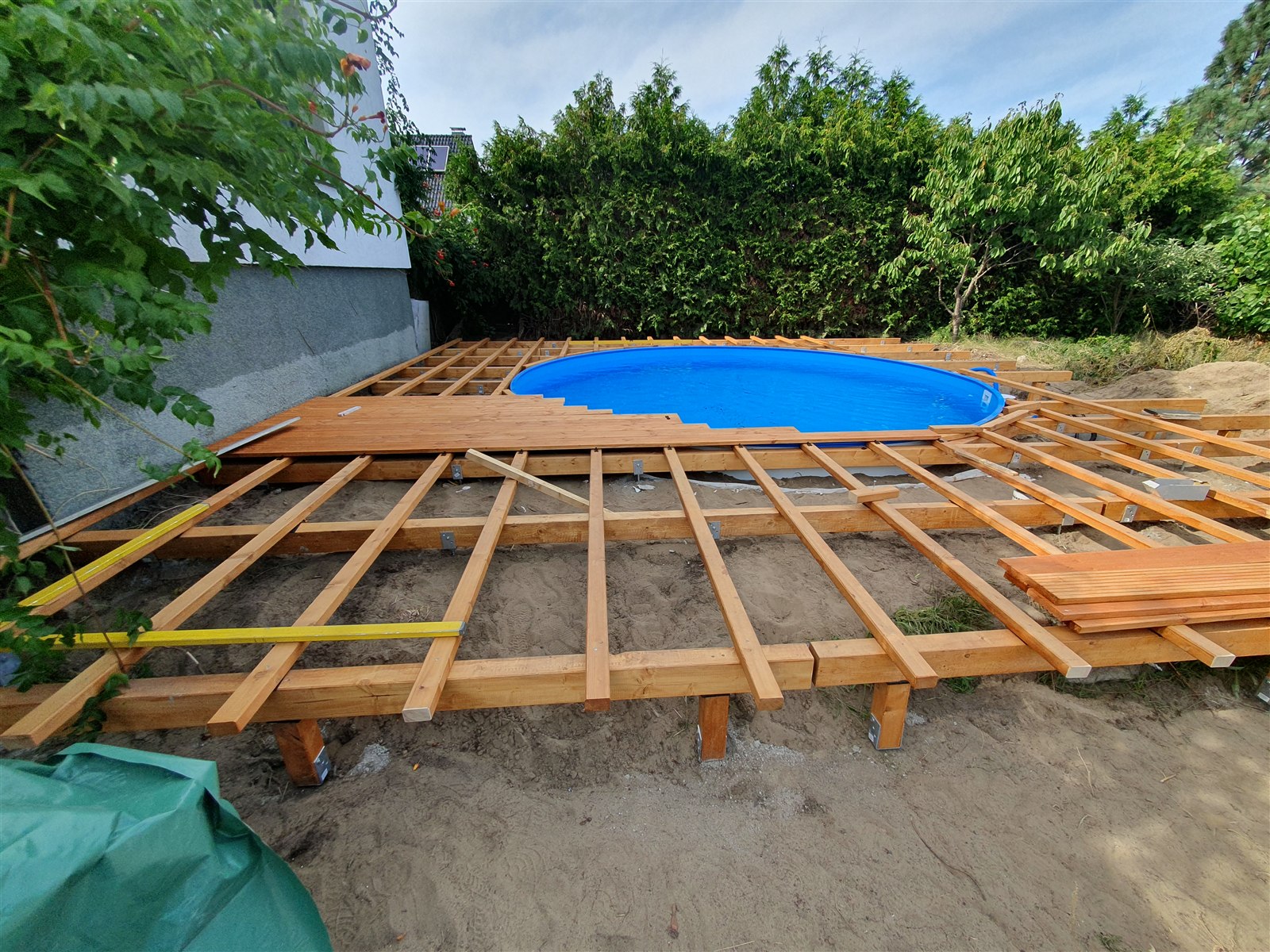 Weiter aufgebaute Holzträger und Rundung am Pool vor der Dielenmontage