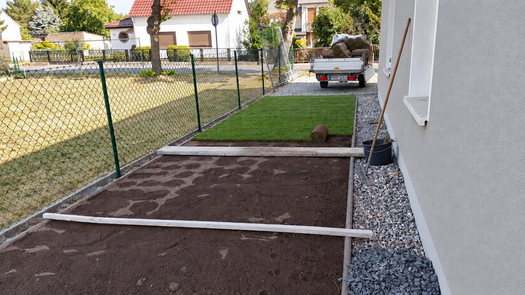 Teilweise mit Rollrasen belegte Gartenfläche während der Installation einer Bewässerung