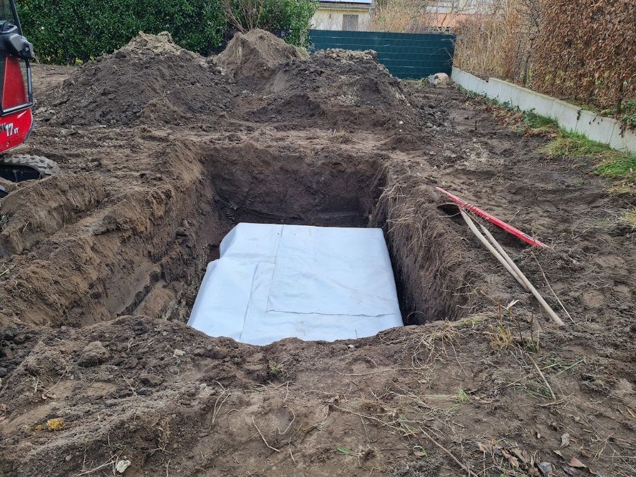Ausgehobene Gartenbaugrube mit weißem Vlies auf der Sohle